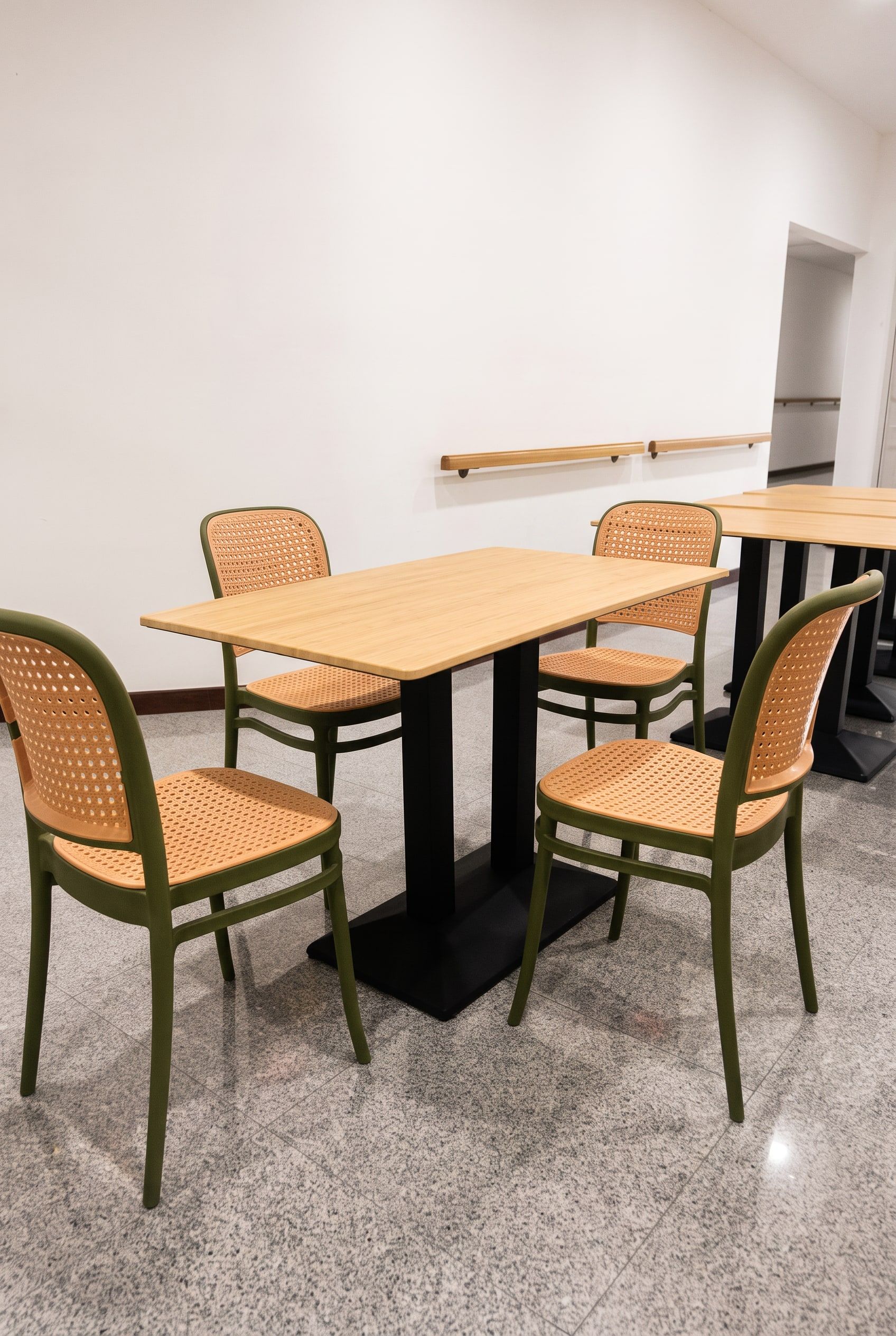 The dining room's bamboo-top tables and green rattan chairs