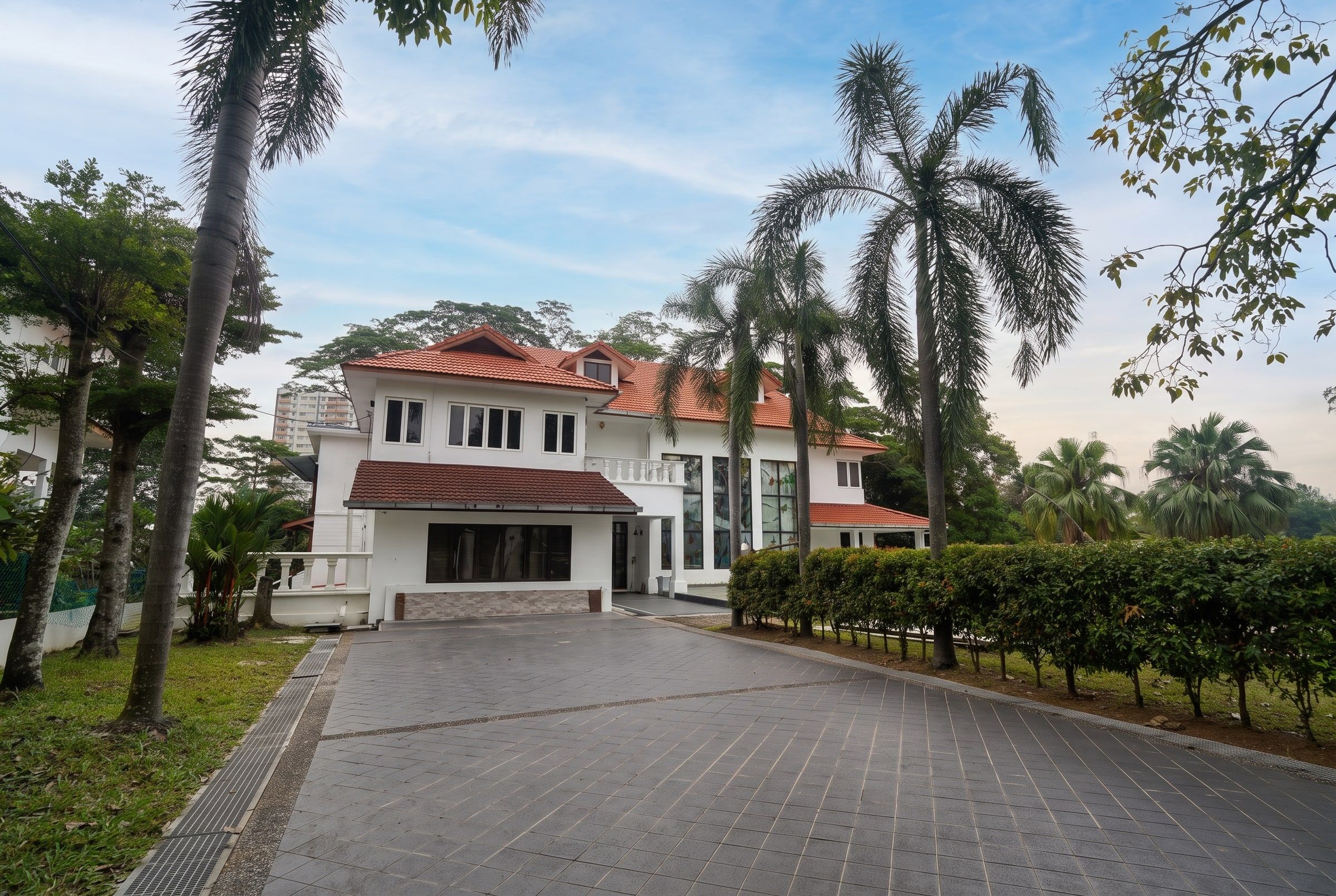 Palm-lined driveway leading to the Trivelle Living residence