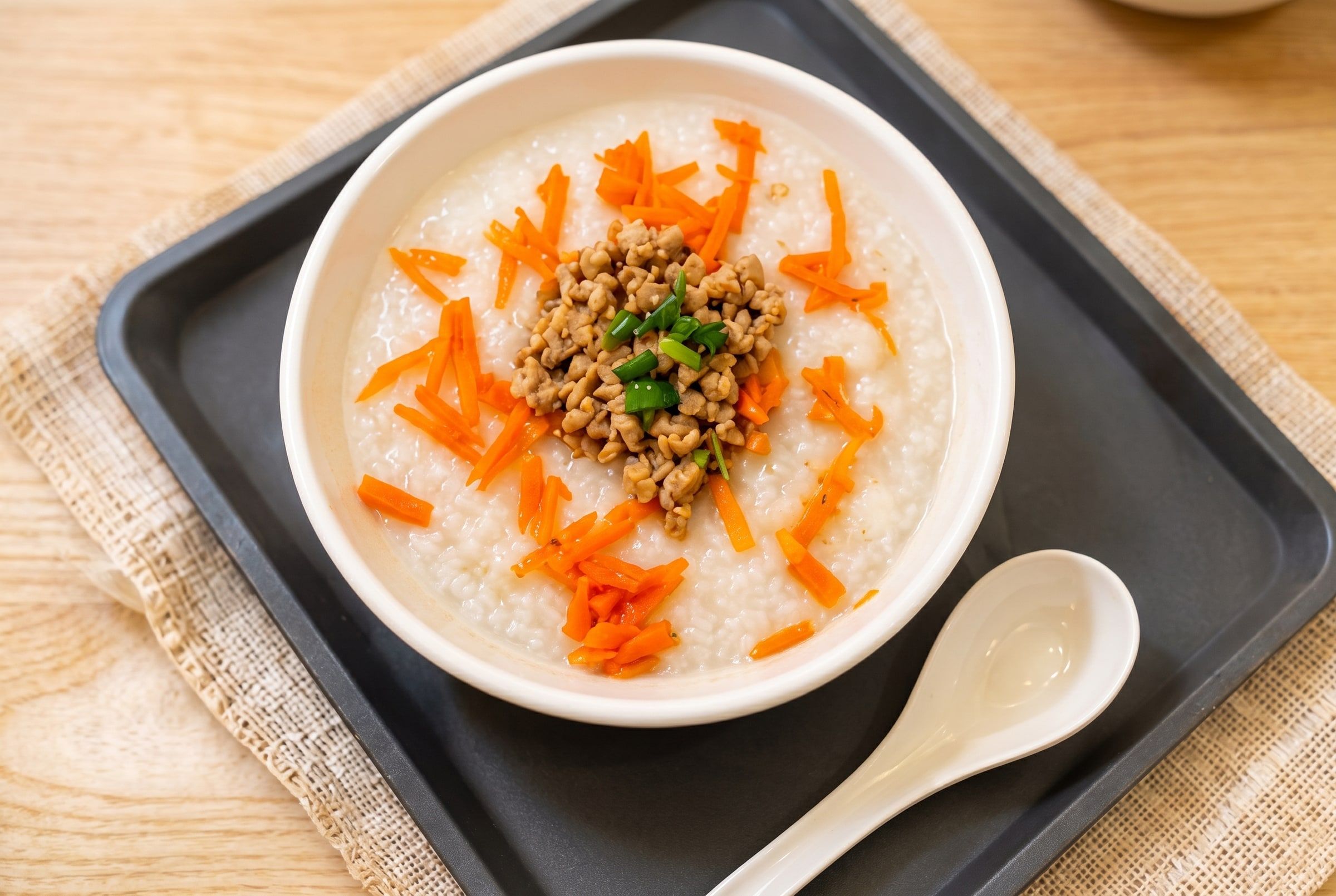 Minced meat congee topped with shredded carrot