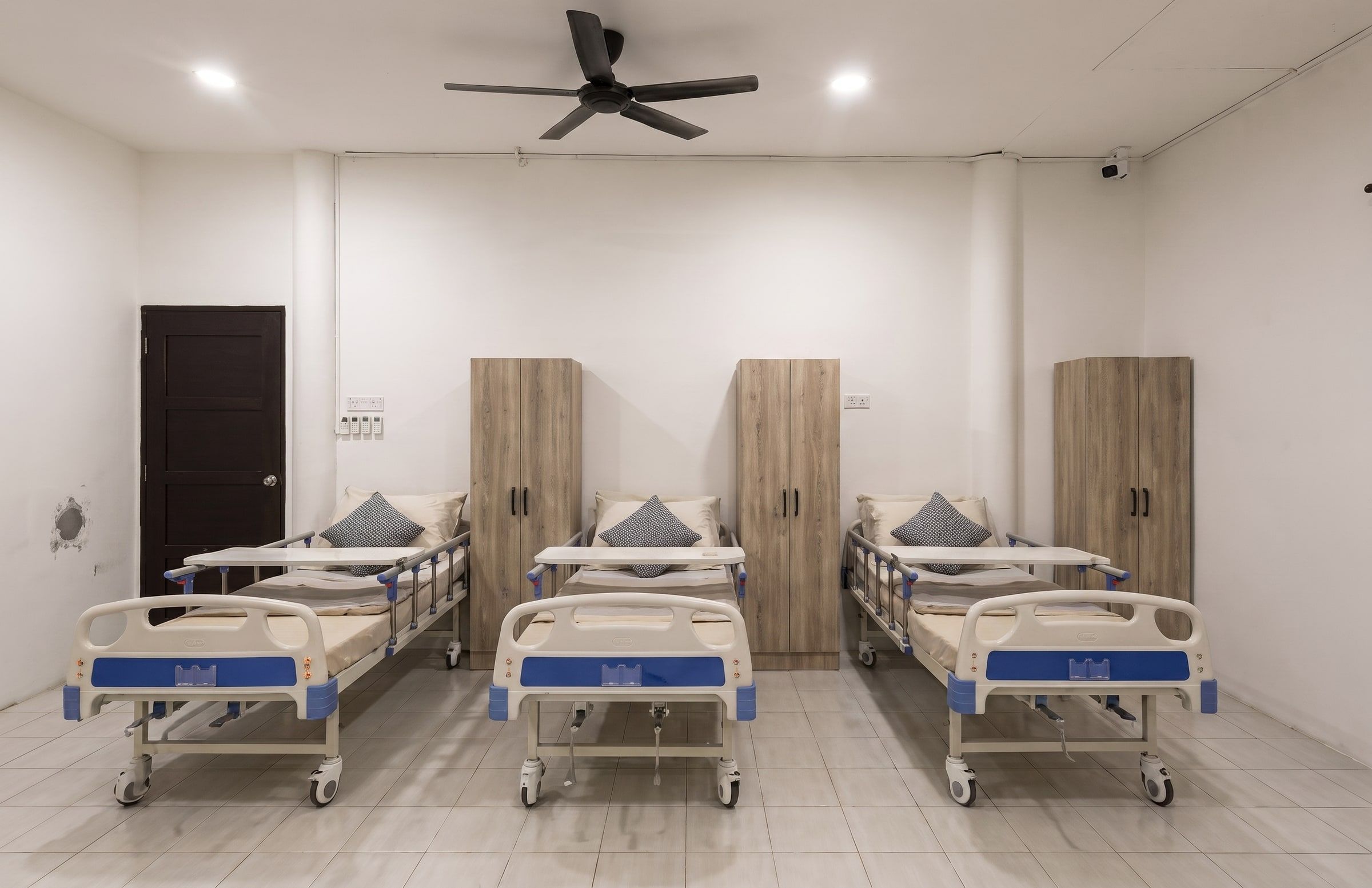 Renovated medical room with adjustable beds, safety rails and wardrobes