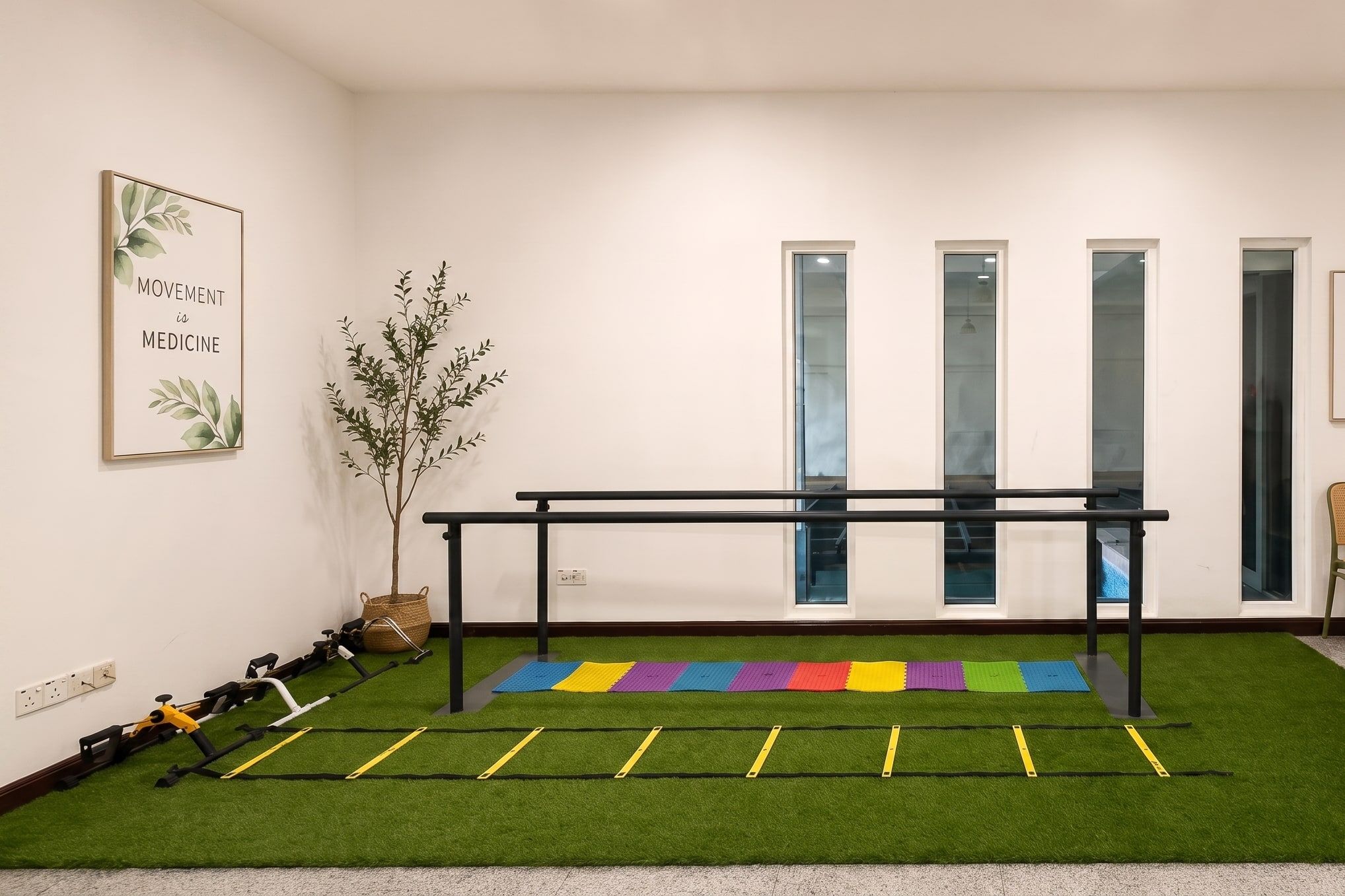 The renovated physiotherapy room with parallel bars, agility ladder and exercise turf