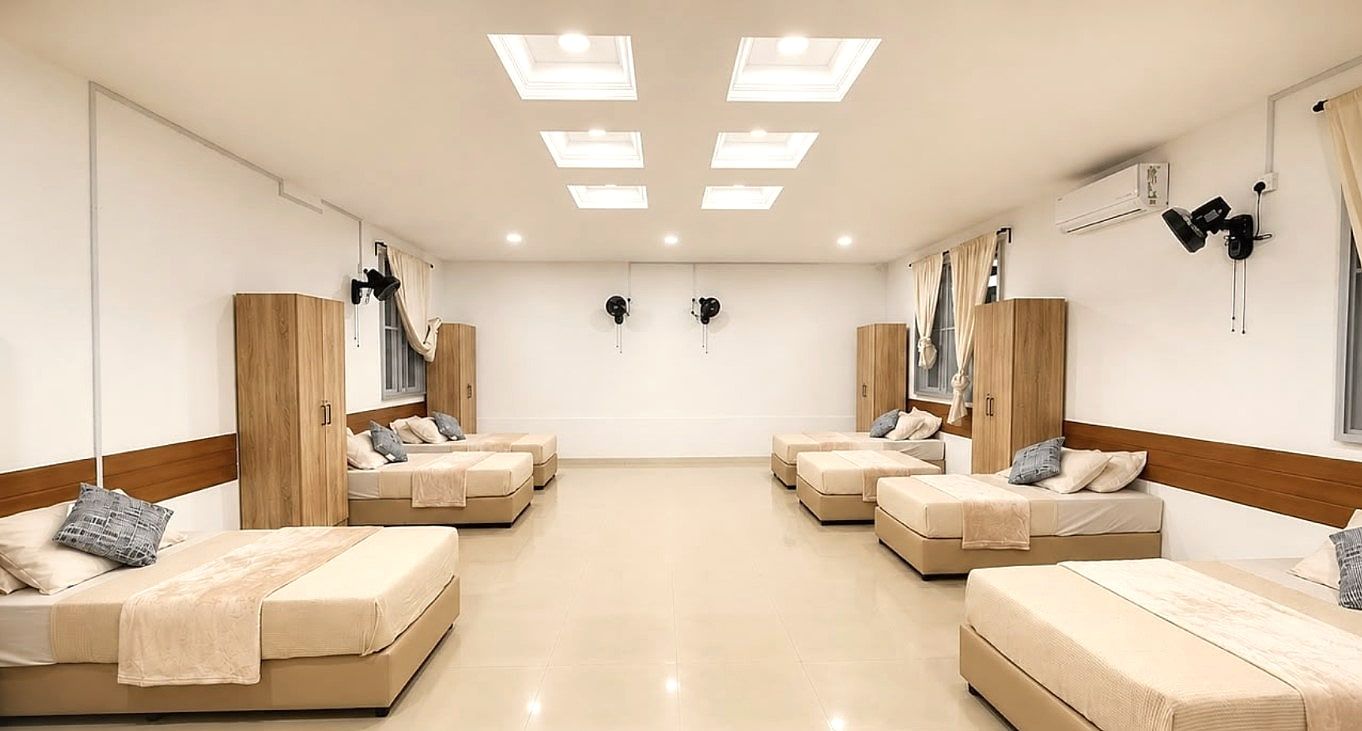 6-Sharing Room — renovated shared room with beds along the walls and skylights