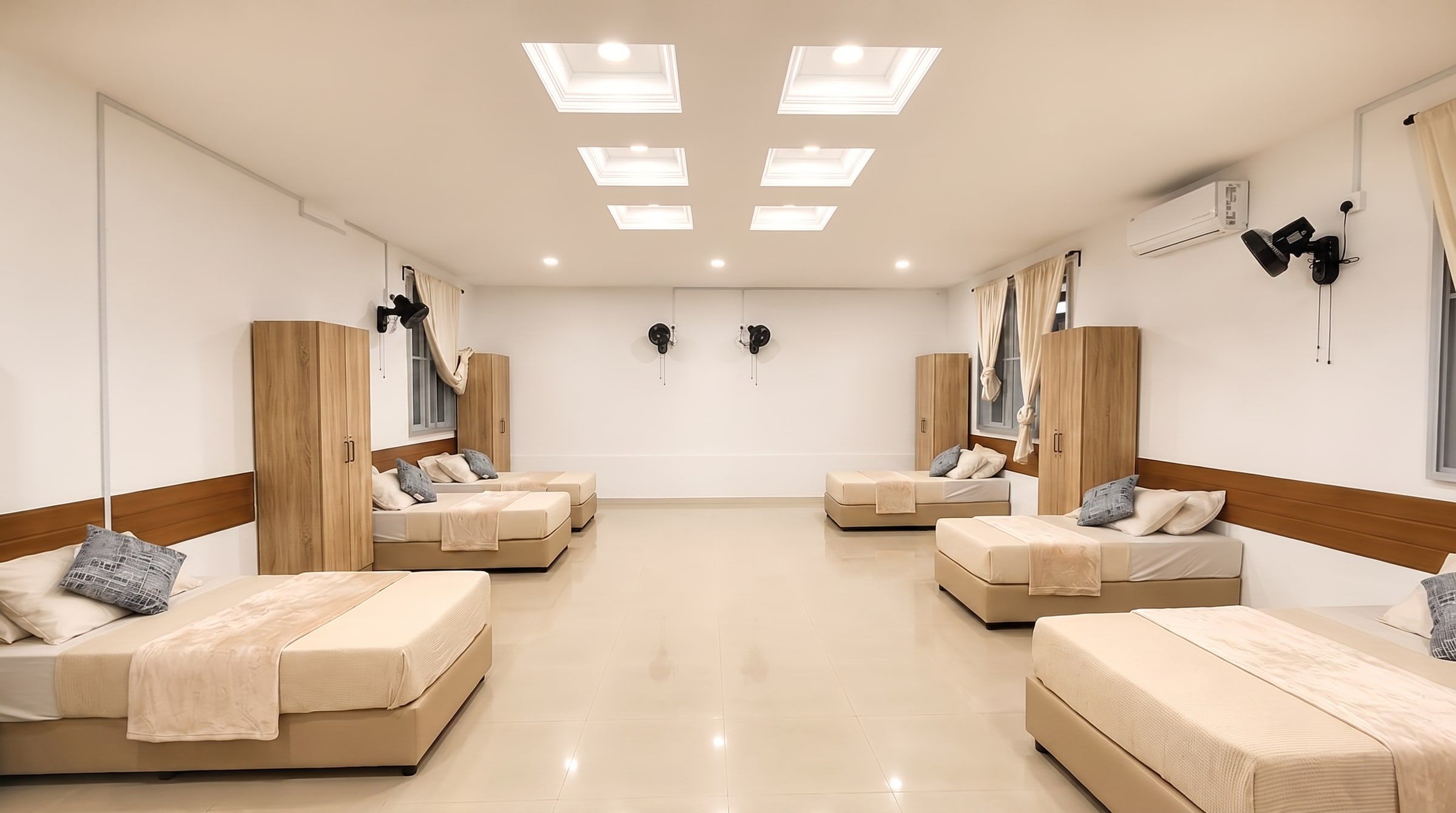 6-Bed Room — renovated shared room with beds along the walls and skylights