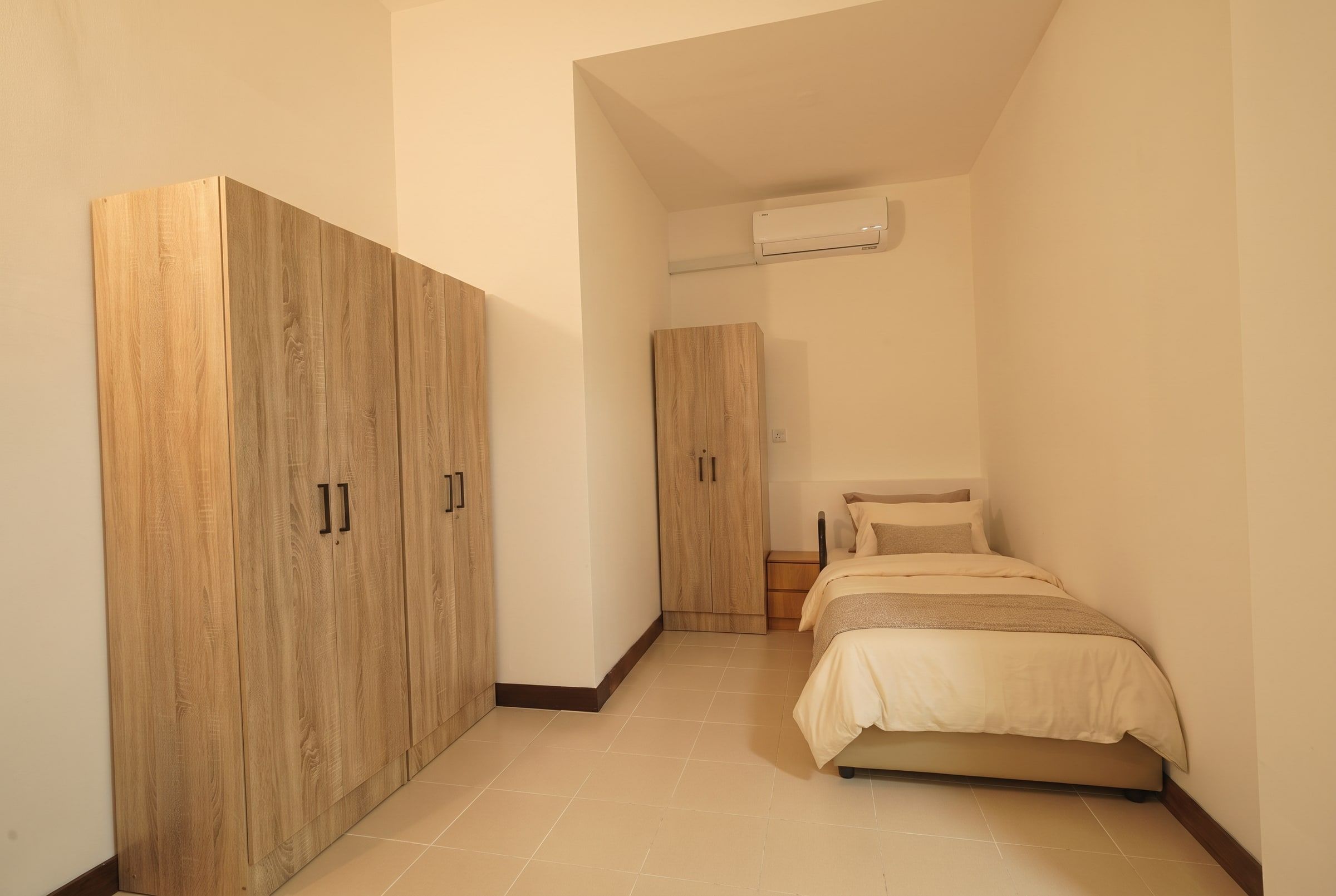 Resident bed with grab rail beside spacious wardrobes