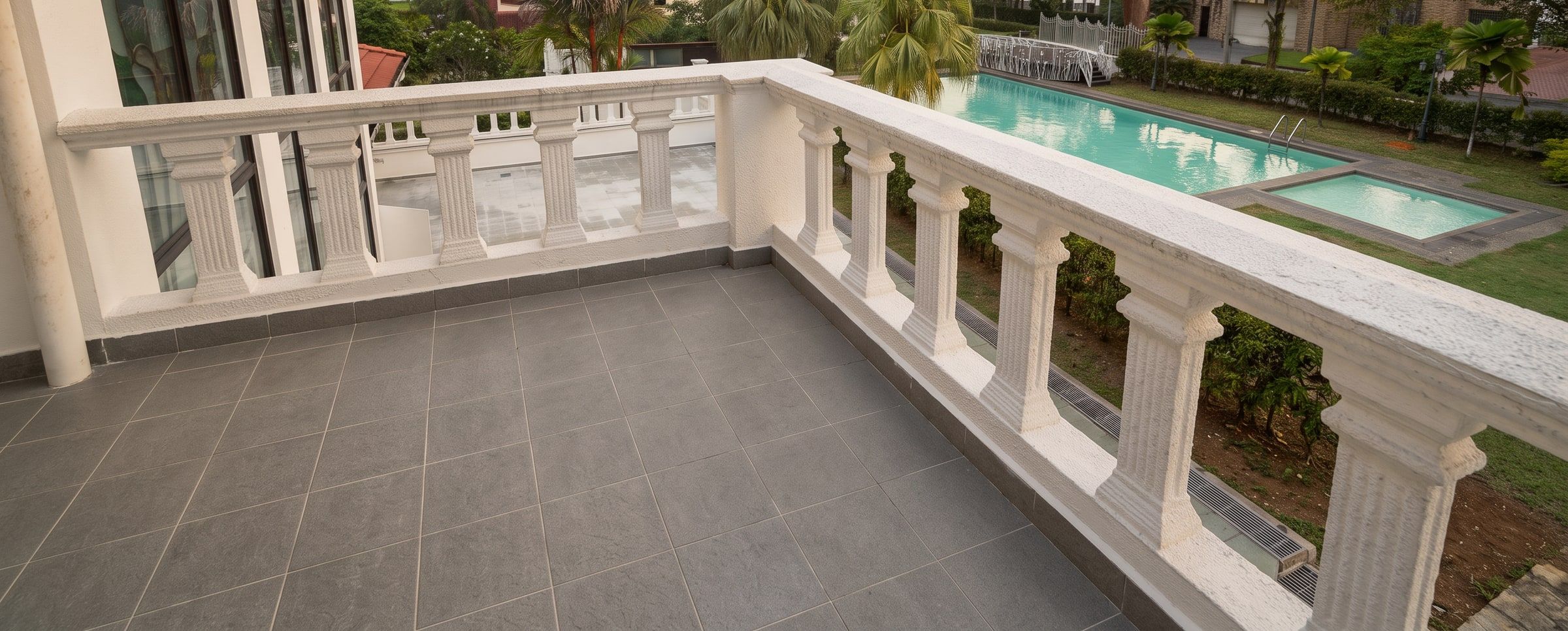 White balustrade of the terrace overlooking the pool and gardens