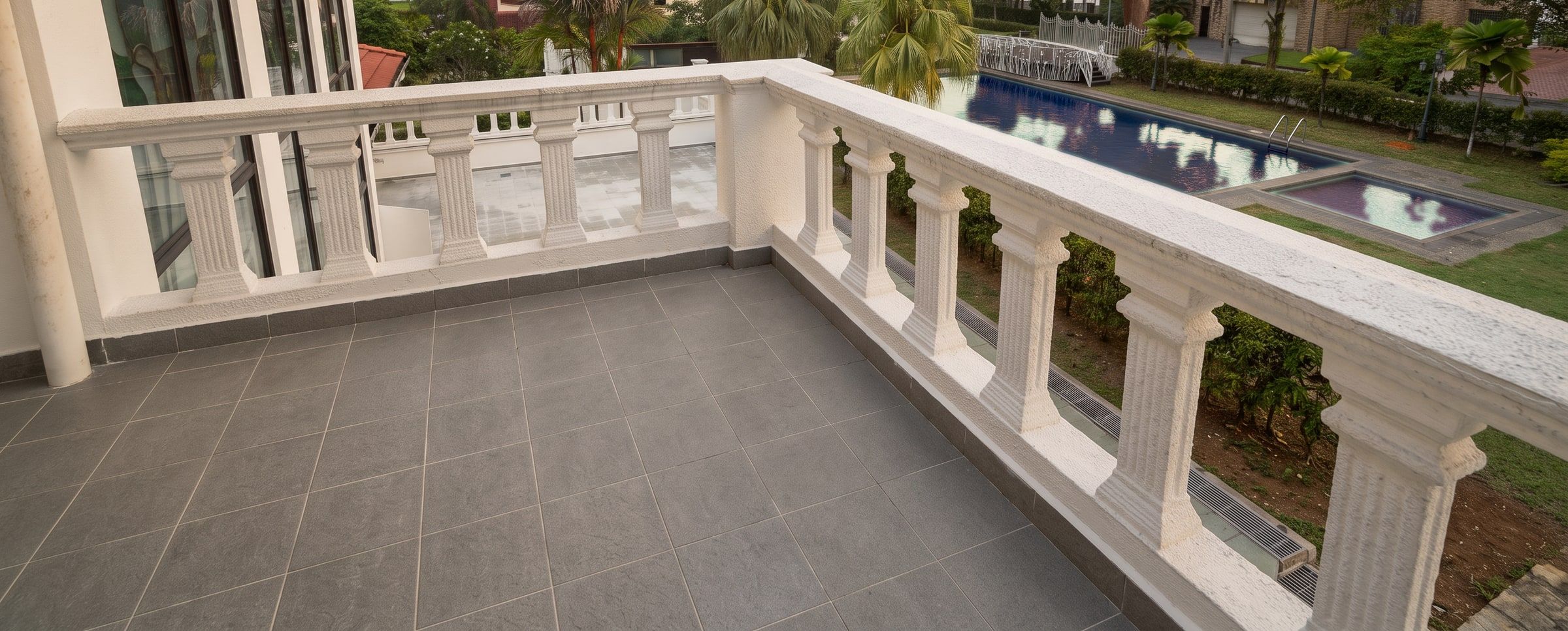 White balustrade of the terrace overlooking the pool and gardens
